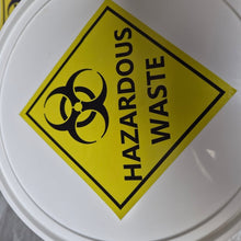 Load image into Gallery viewer, White container with a yellow hazardous waste label featuring a biohazard symbol.
