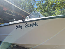 Load image into Gallery viewer, Boat named 'Salty Starfish' with a blurred background of trees and a building.