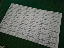 Load image into Gallery viewer, Sheet of labels with 'Service Due' text on a green cutting mat