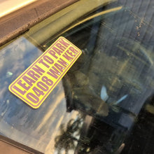 Load image into Gallery viewer, Yellow Learn to park wanker sticker sticker on a car windshield with reflections.