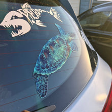 Load image into Gallery viewer, Car window with a turtle decal and another design on a reflective surface