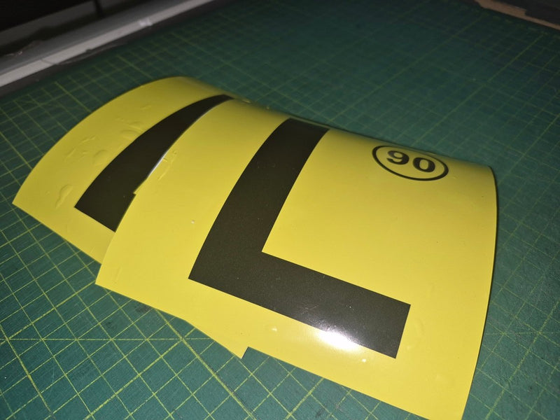 Yellow and black traffic sign on a green cutting mat