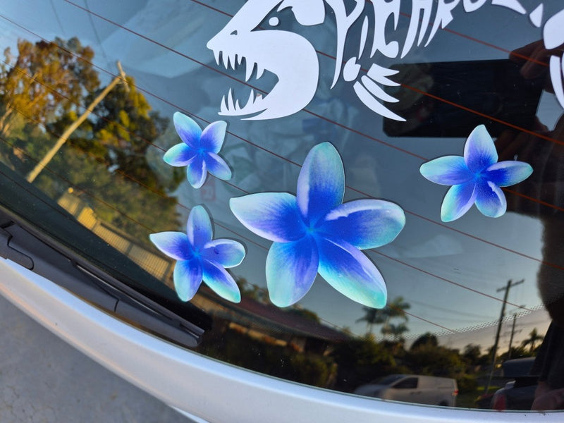 Frangipani Blue flower decals on a car window with a shark decal in the background.