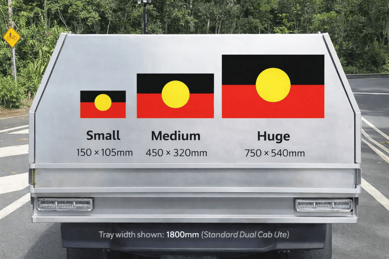 Truck bed with size indicators for different aboriginal flag designs on a road.