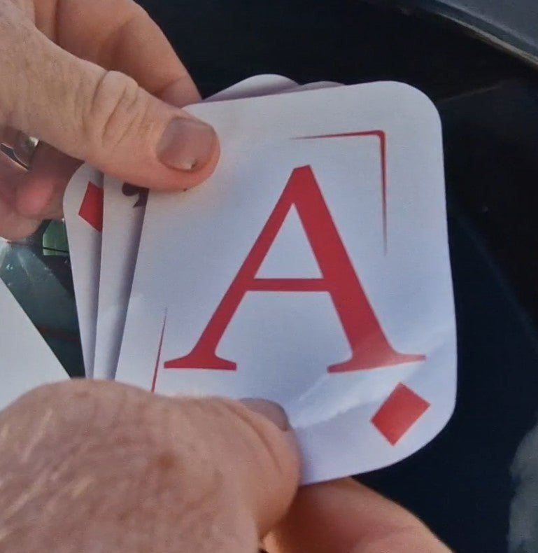 Hand holding a card with the letter 'A' on it