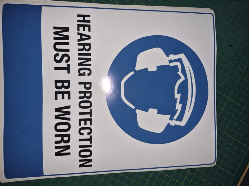 Sign with hearing protection symbol and text on a green cutting mat