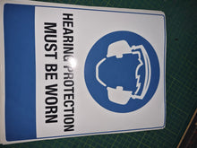 Load image into Gallery viewer, Adhesive vinyl Sign with a hearing protection symbol and text on a cutting mat
