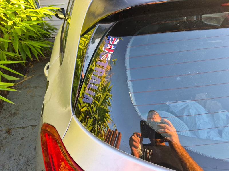 Australian Australia flag sticker design a car's rear window with a reflection of plants.