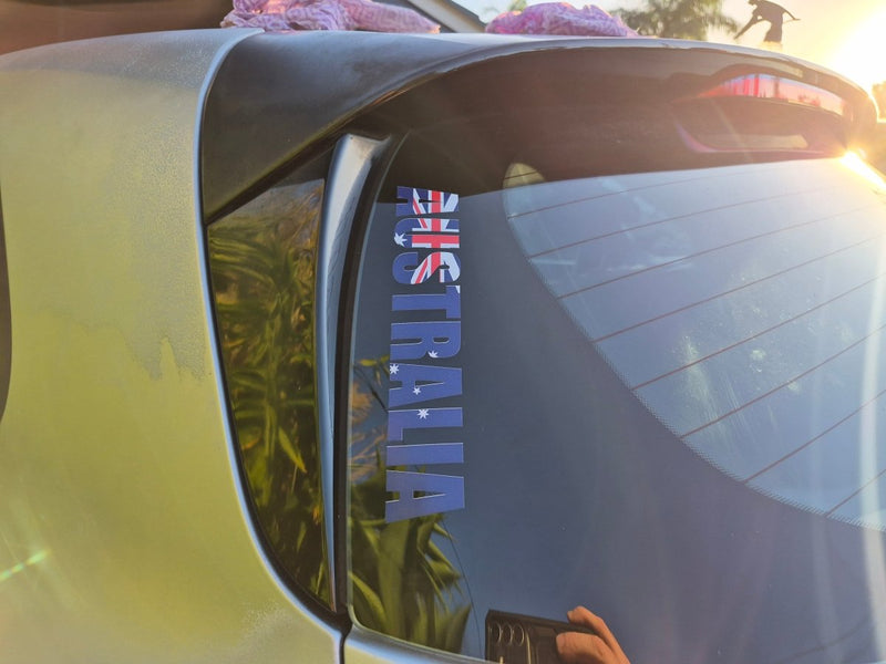 Car window with 'Australia' decal and Australian flag, blurred background