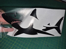 Load image into Gallery viewer, Black shark decal on a white sheet with a hand touching it, on a green cutting mat.
