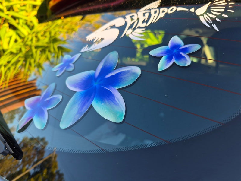 Frangipani Blue flower decals on a car window with blurred outdoor background