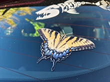 Load image into Gallery viewer, Butterfly on a car windshield with a dragon design in the background
