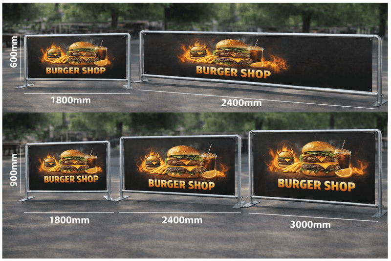 Burger shop signboards of different sizes on a wooden surface with a blurred outdoor background.