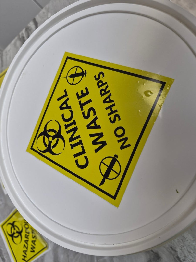 Clinical waste sticker with biohazard symbol and warning text on a gray background