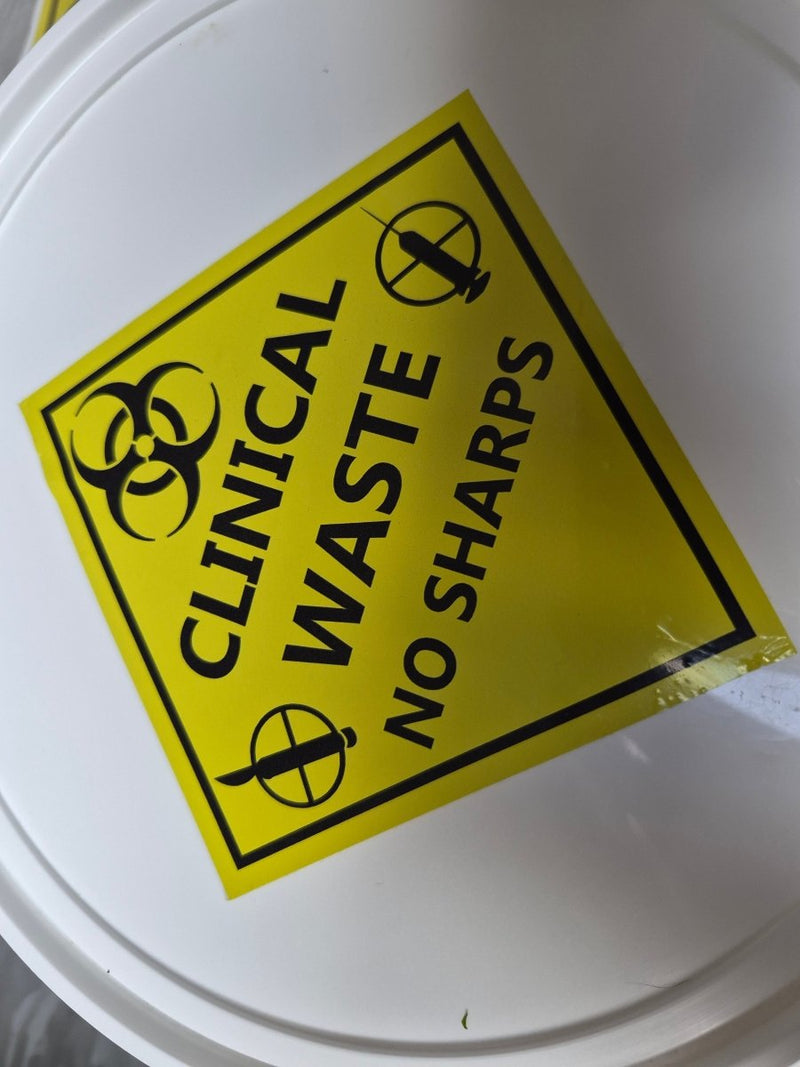 Yellow 'Clinical Waste No Sharps' sign on a white background