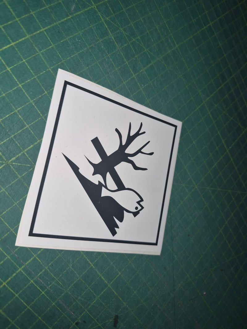Black and white sticker with tree and bird design on a green cutting mat