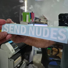 Load image into Gallery viewer, Hand holding a sticker with 'SEND NUDES' text in an indoor setting.

