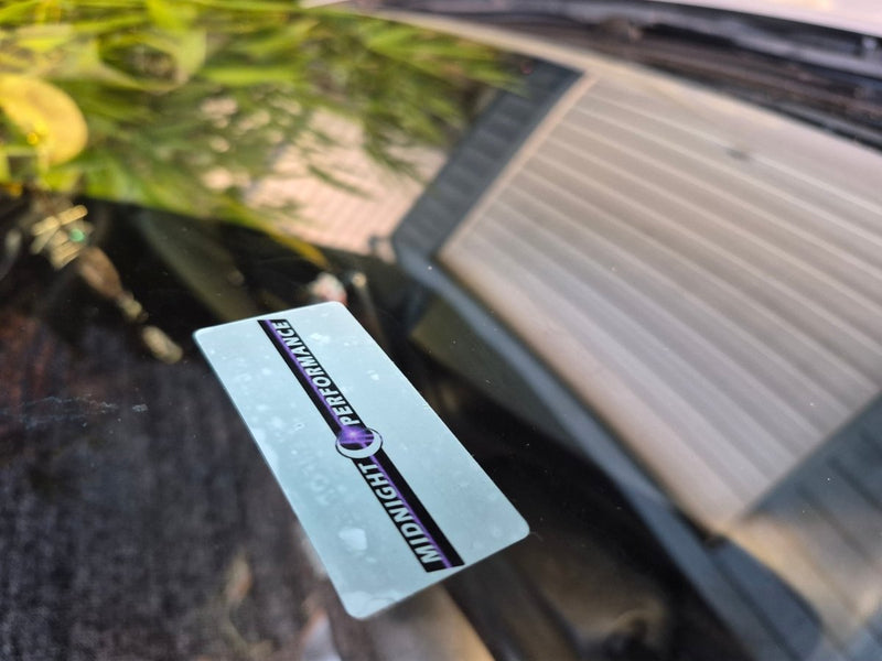 Decal with 'Midnight Performance' logo on a car Service due seen from the outside of the car