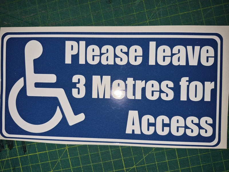 Blue sign with white text and wheelchair icon on a green cutting mat