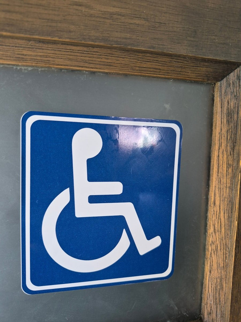 Disbaled stickers on a door, just the chair symbol 