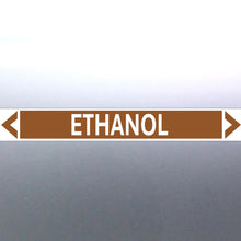 Load image into Gallery viewer, A pipe marker label with the word 'ETHANOL' in bold black lettering on a golden tan background with a white border and green directional arrows pointing in both directions.
