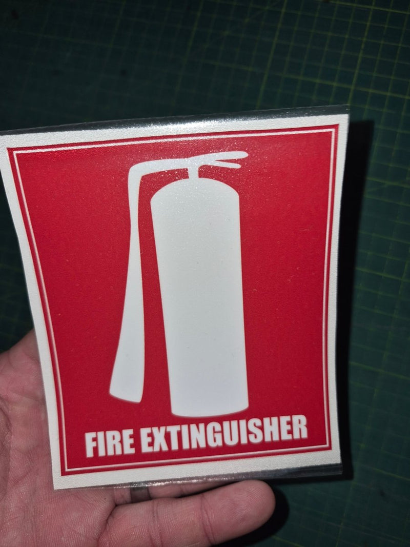 Fire extinguisher sign held by a hand on a dark grid background