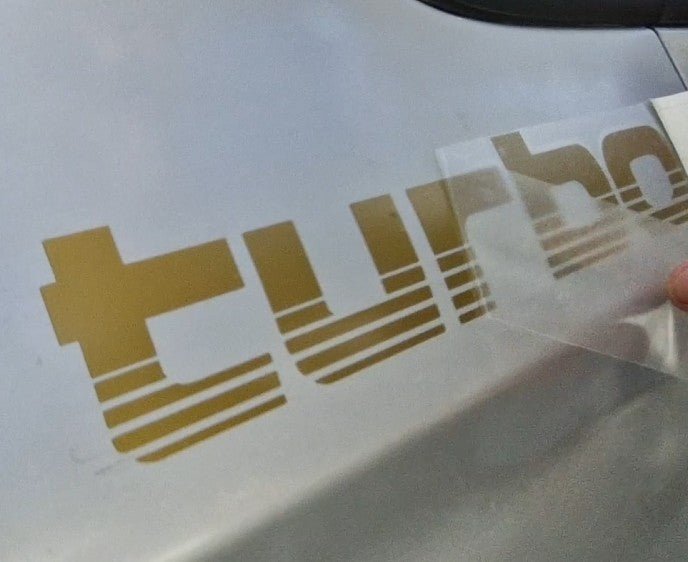 Gold 'Turbo' decal on a white surface