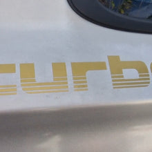 Load image into Gallery viewer, Gold 'turbo' decal on a car's white surface

