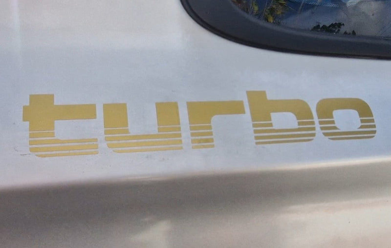 Gold 'turbo' decal on a car's white surface
