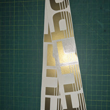 Load image into Gallery viewer, Set of 'Turbo' decals on a green cutting mat with grid lines
