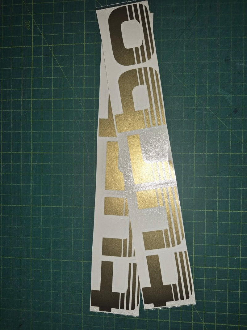 Set of 'Turbo' decals on a green cutting mat with grid lines