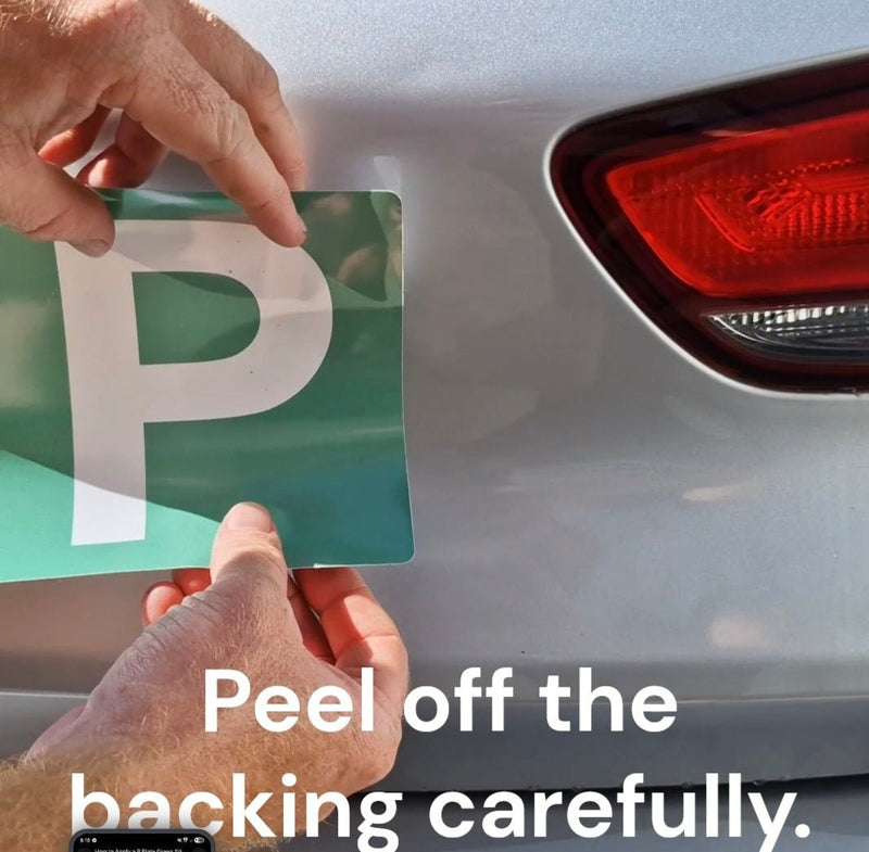 Person peeling a green and white 'P' plate from a car, with text instructing to peel off the backing carefully.
