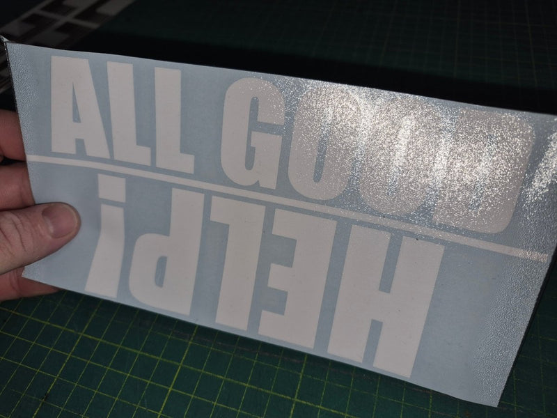 Vinyl decal with text held over a cutting mat