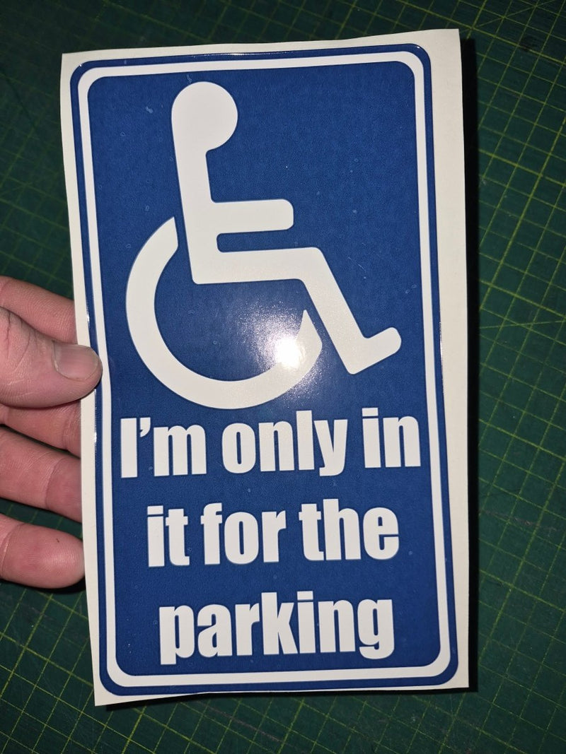 Handheld blue and white sign with wheelchair icon and text on a green cutting mat.