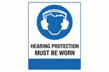 Load image into Gallery viewer, Sign with a blue circle featuring a white icon of ear protectors and text 'HEARING PROTECTION MUST BE WORN' on a white background.
