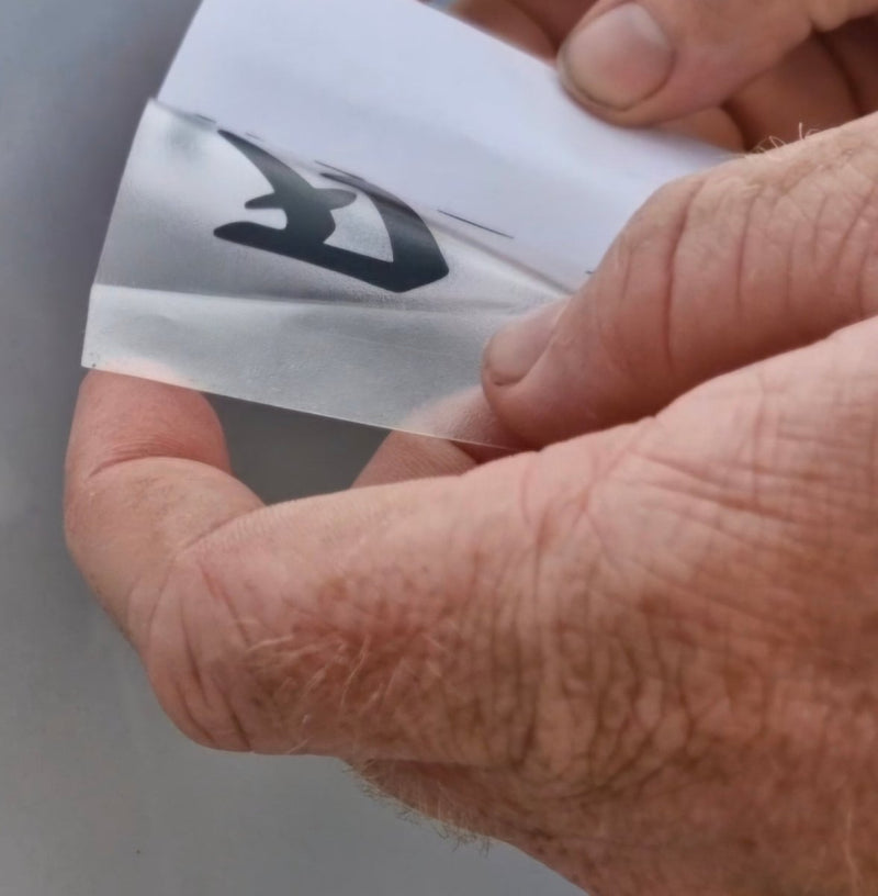 Hand holding a small white card with black text against a neutral background