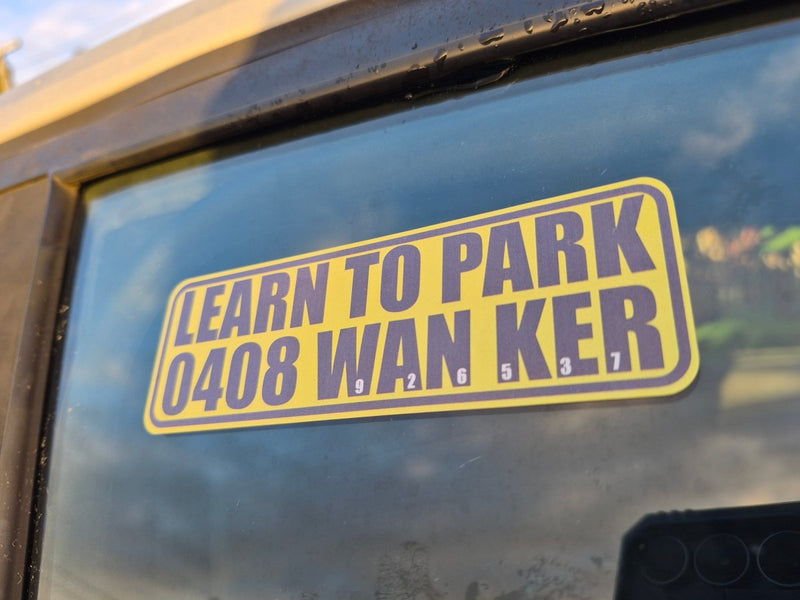 Yellow and purple 'LEARN TO PARK 0408 WAN KER' sticker on a car window.
