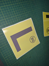 Load image into Gallery viewer, Yellow square with a purple 'L' and black number '80' on a green grid background

