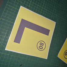 Load image into Gallery viewer, Yellow square with a purple 'L' and black number '80' on a green grid background
