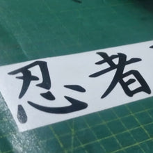 Load image into Gallery viewer, Ninja Black text on a white strip with green cutting mat background
