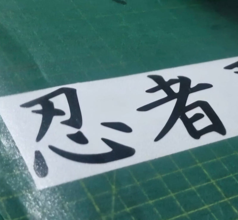 Ninja Black text on a white strip with green cutting mat background