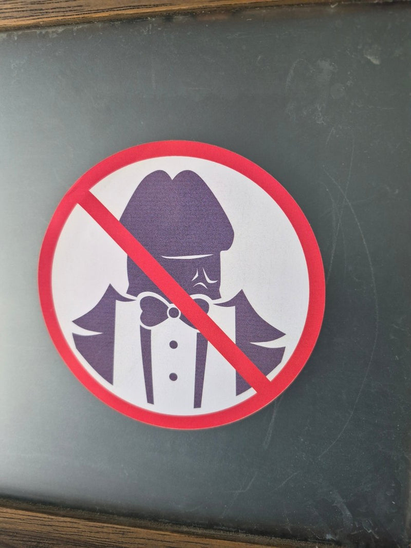 No Dickheads Allowed decal with a red circle and diagonal line over a purple and white illustration on a dark background.