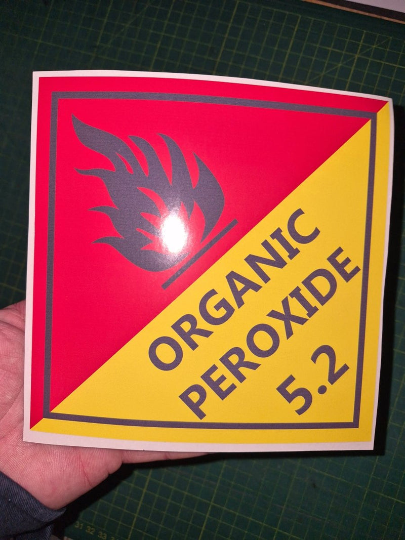 Organic Peroxide 5.2 Sticker with a red and yellow warning triangle and text on a cutting mat.