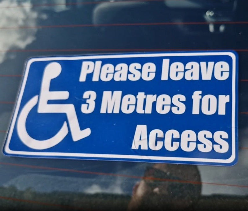 Handicap access request Sticker on a vehicle window with text 'Please leave 3 Metres for Access'.