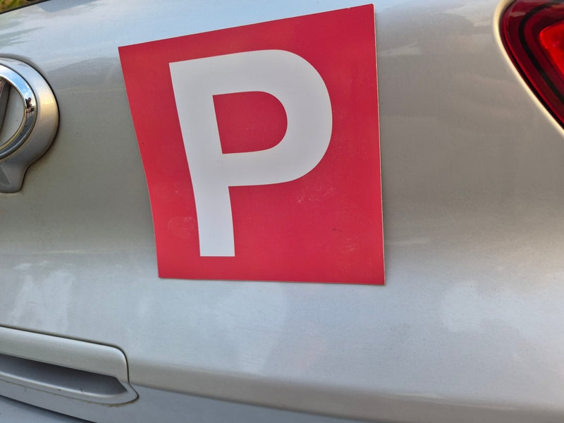 Provisional magnets for P plate drivers Red and white 'P' plate on a car, indicating a learner driver.