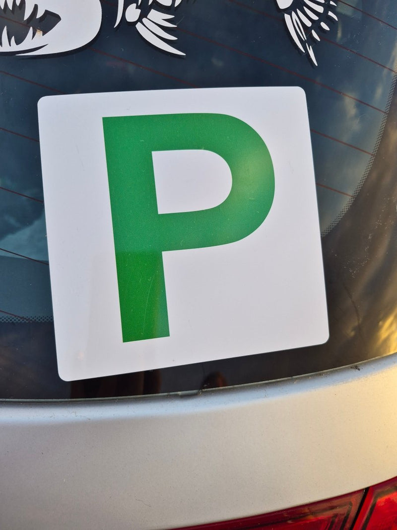 Green and white 'P' plate on a car window