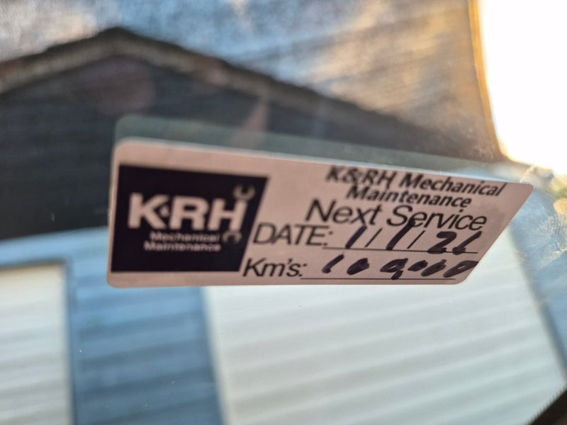 Real customers logo on our service due labels K&RH Mechanical Maintenance sticker on a vehicle windshield with service details.