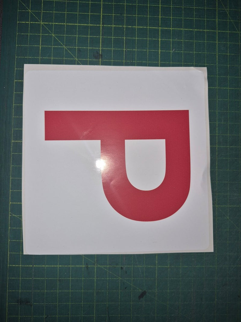 Red 'P' letter on a white background with a green cutting mat.