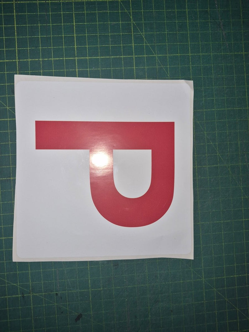 Red 'P' on a white square with a green cutting mat background