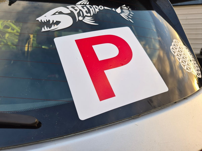 P-plate on a car window with decorative elements.